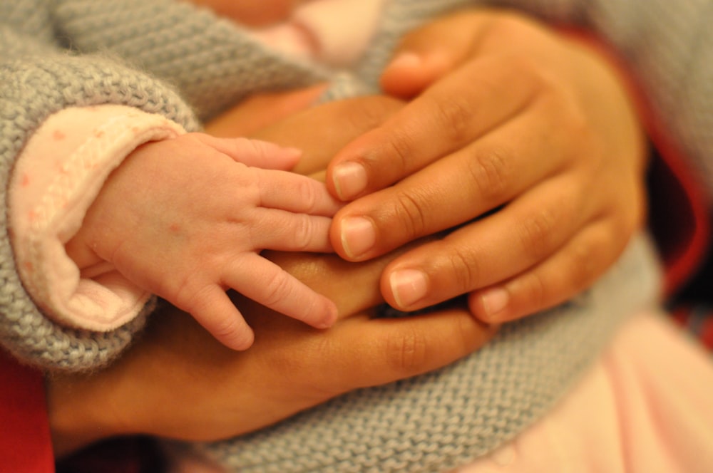 persons hand on white knit textile