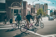 man in black jacket riding on bicycle during daytime