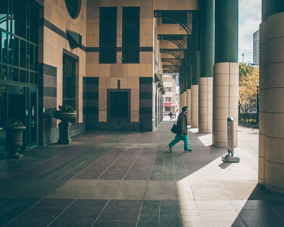 people walking on sidewalk near building during daytime