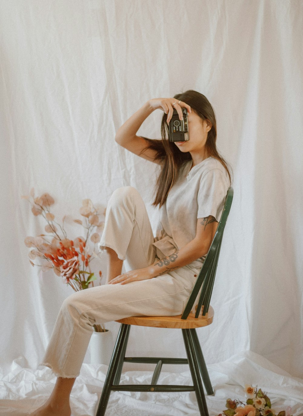 woman in white long sleeve shirt sitting on brown wooden chair