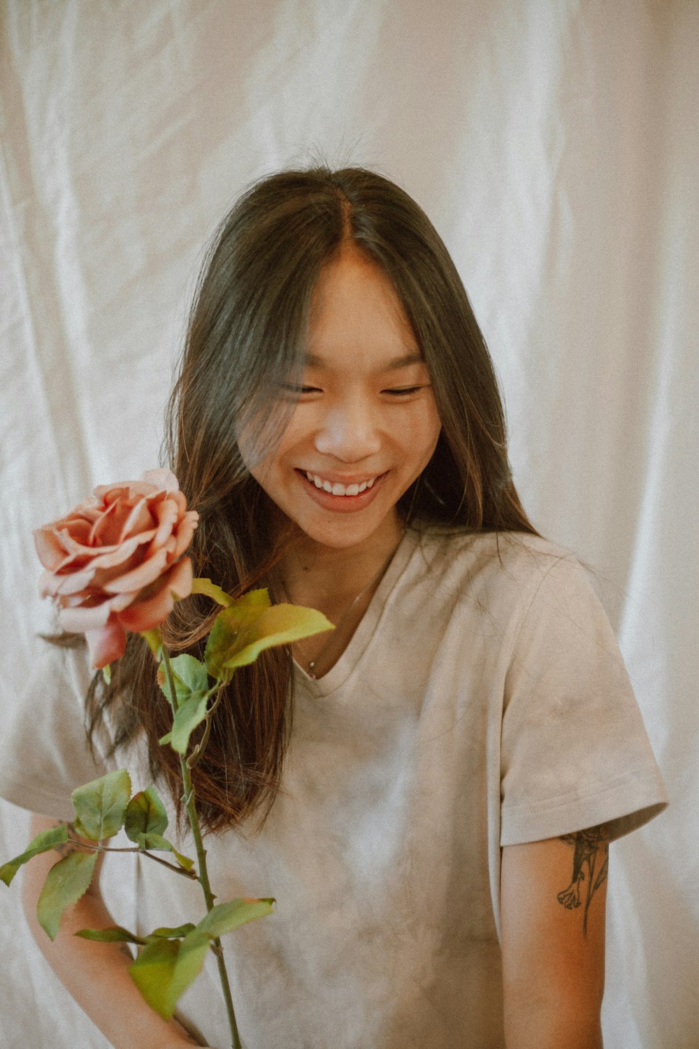 girl in brown long sleeve shirt holding red rose