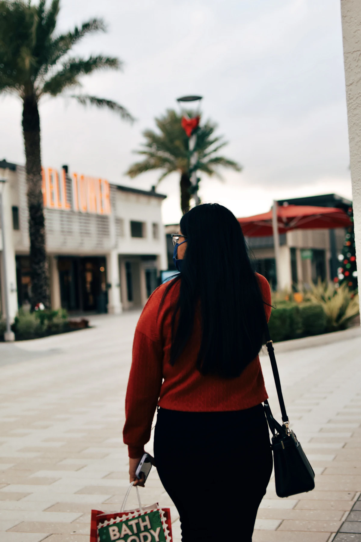 A person standing outside a store impatiently checking their phone while waiting for a page to load