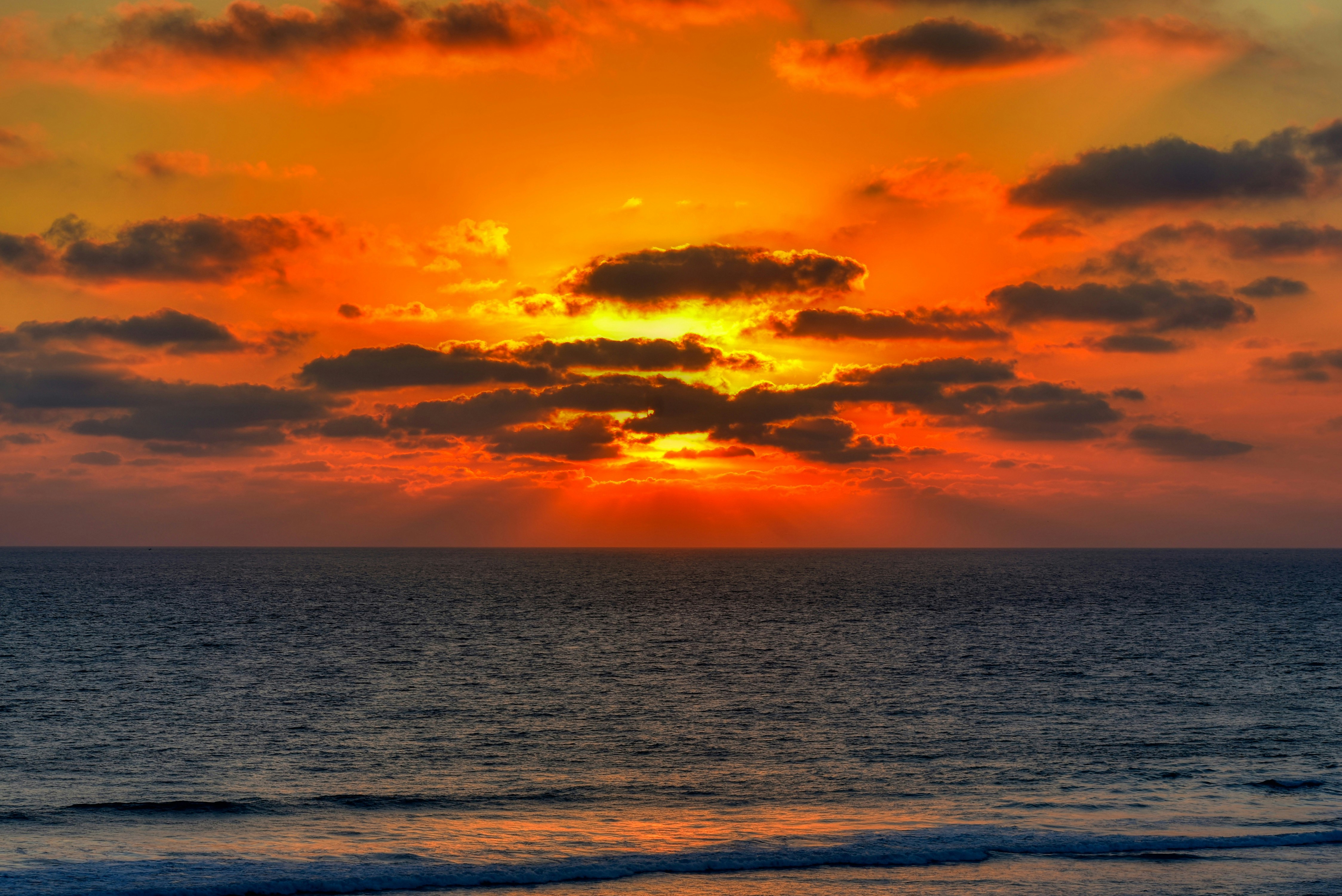 body of water under cloudy sky during sunset