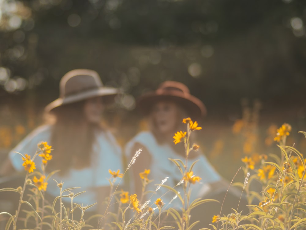 woman in white sun hat sitting on white flower field during daytime