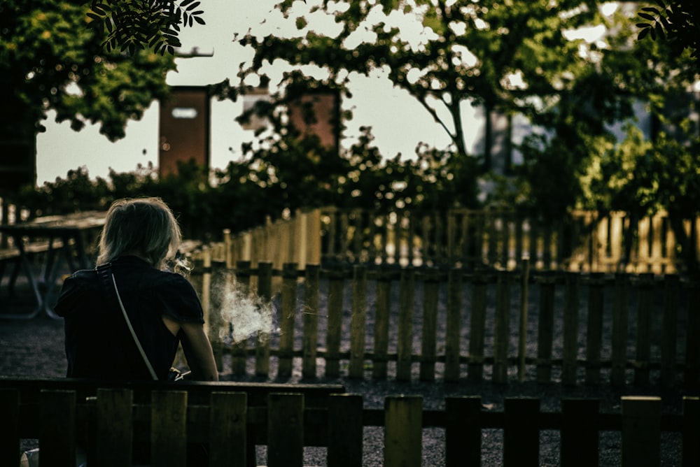 woman in black shirt sitting on bench