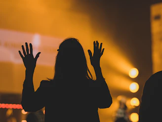 silhouette of woman raising her hands