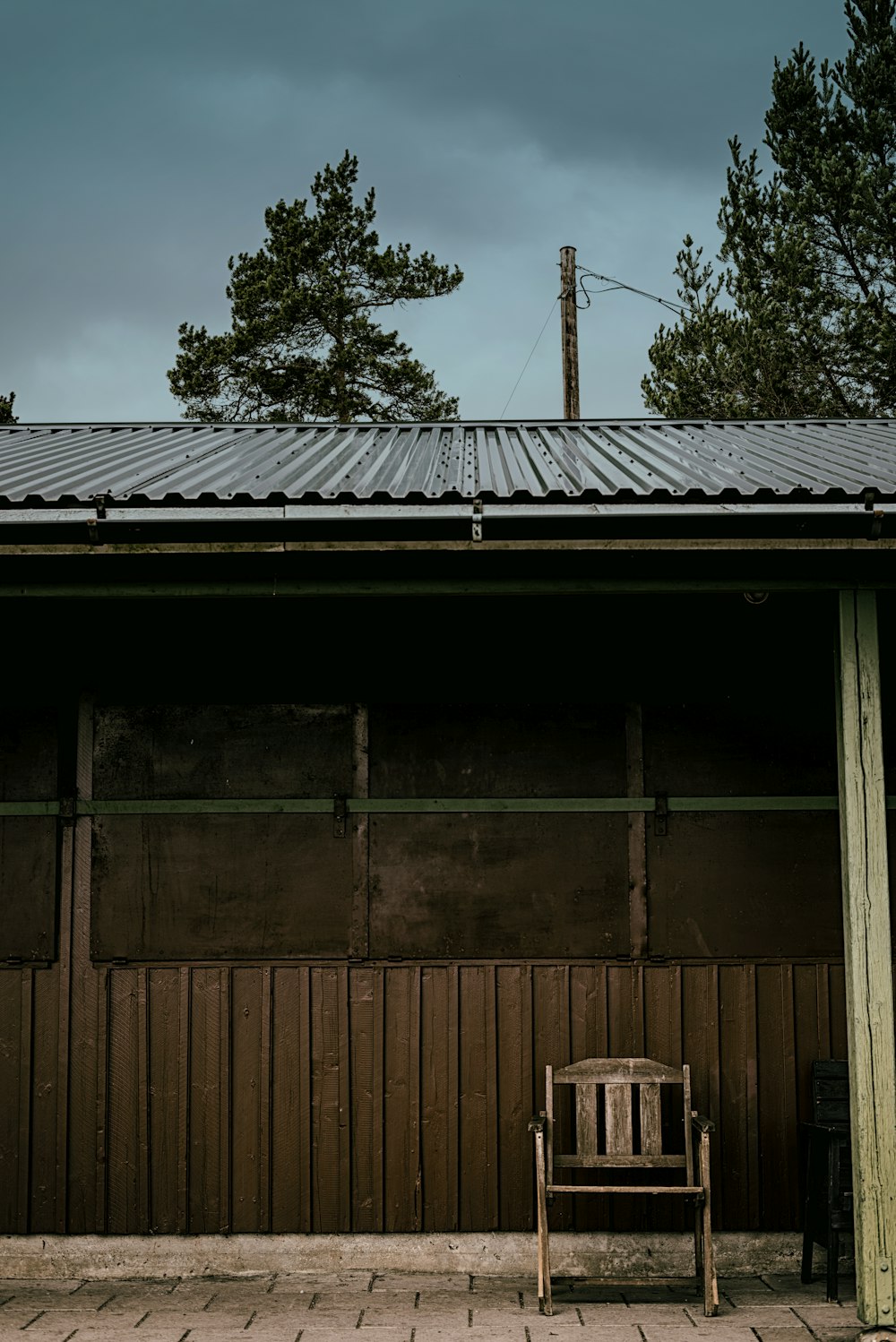 brown wooden house near green trees during daytime