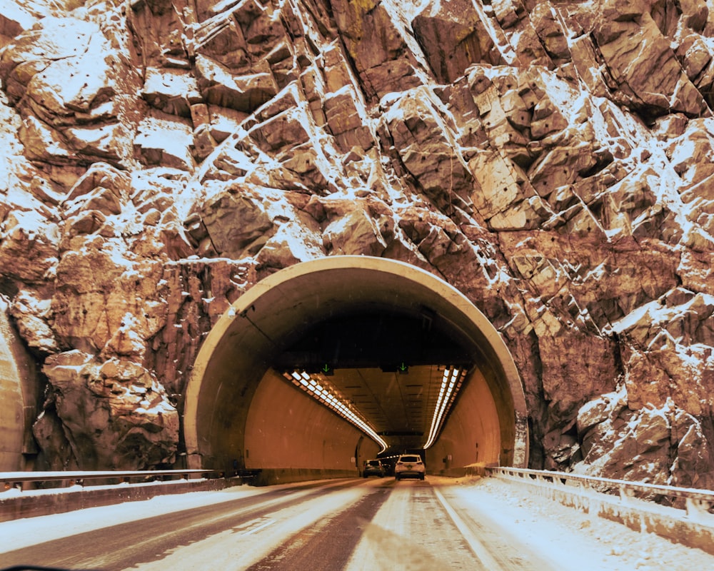 brown tunnel on brown rocky mountain during daytime