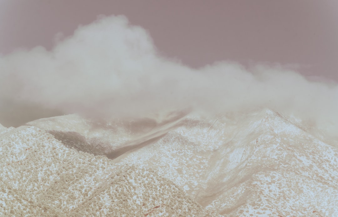 white clouds over snow covered mountain