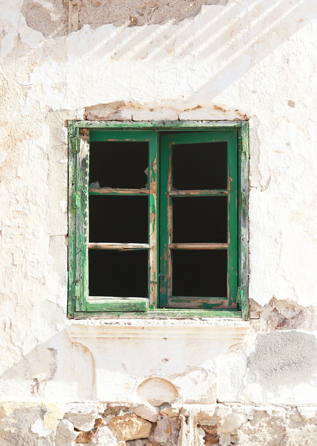 green wooden window frame on white concrete wall