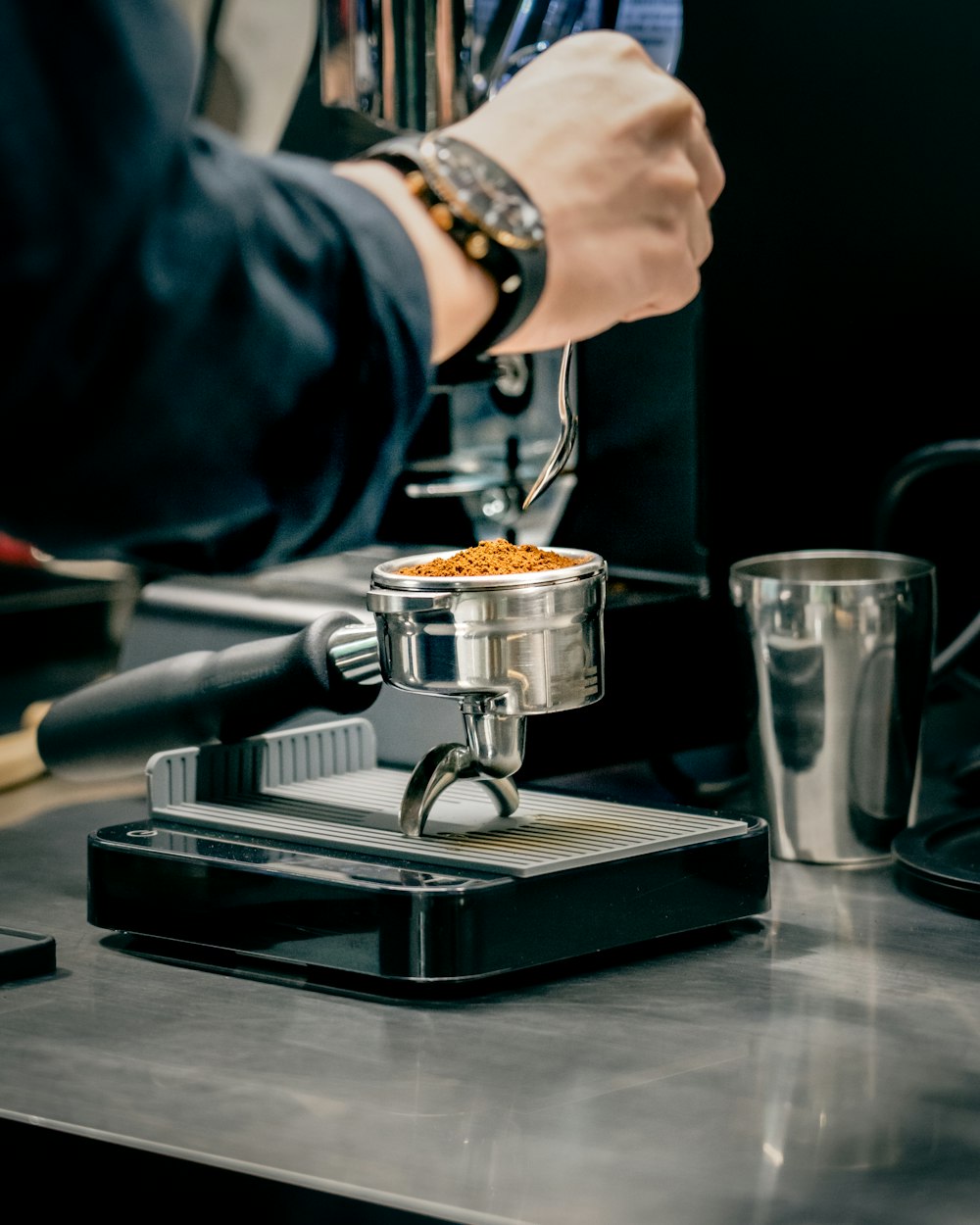 person pouring coffee on silver coffee cup