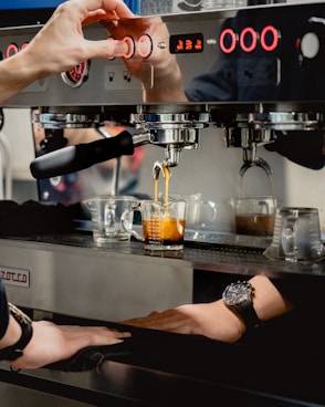 person pouring coffee on clear glass mug