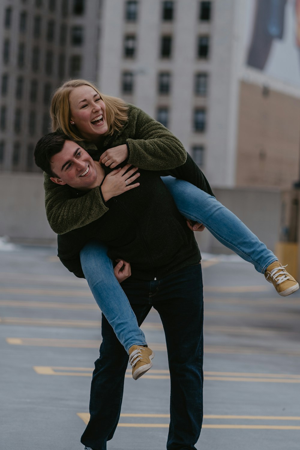 woman in green jacket and blue denim jeans hugging woman in black jacket