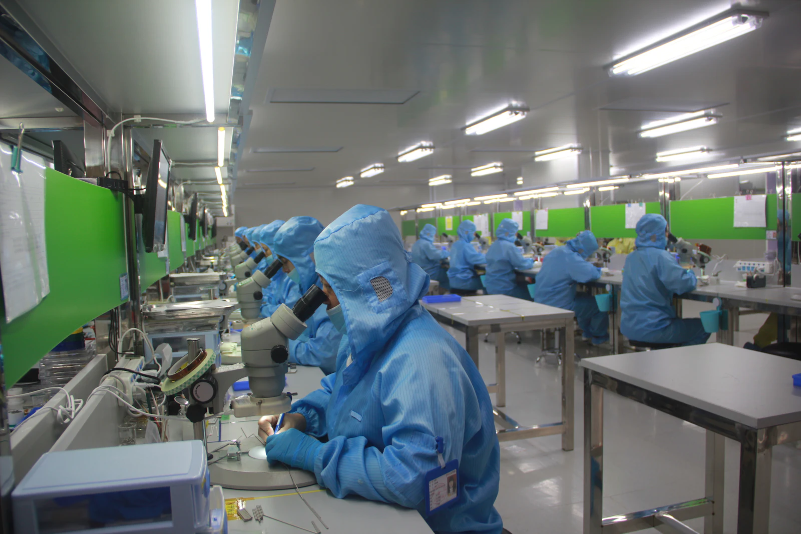 Technician in protective clothing at a pharmaceutical production line