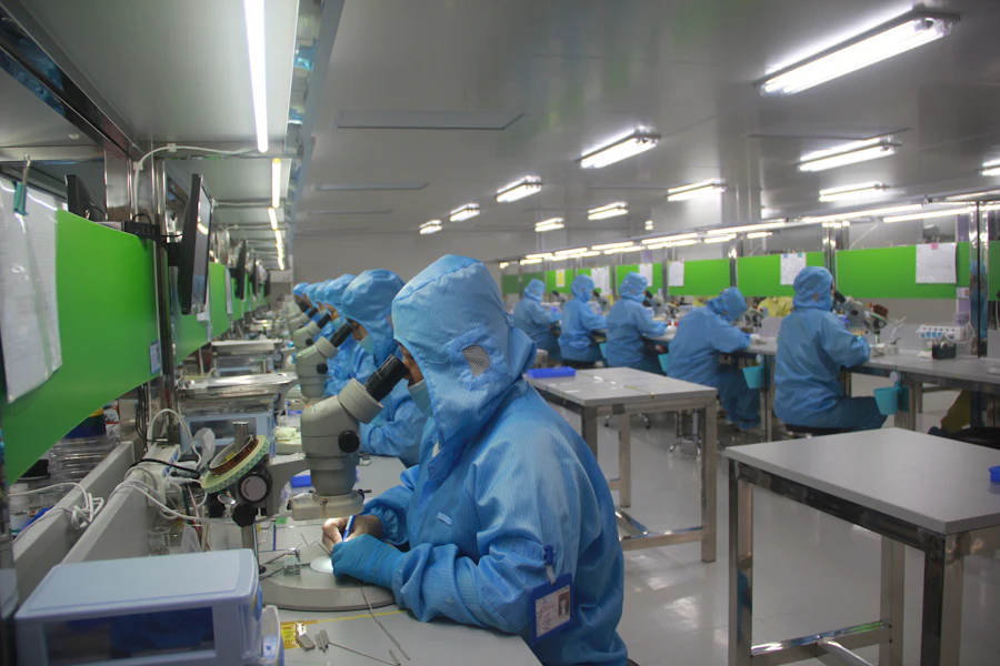 Technician in protective clothing at a pharmaceutical production line