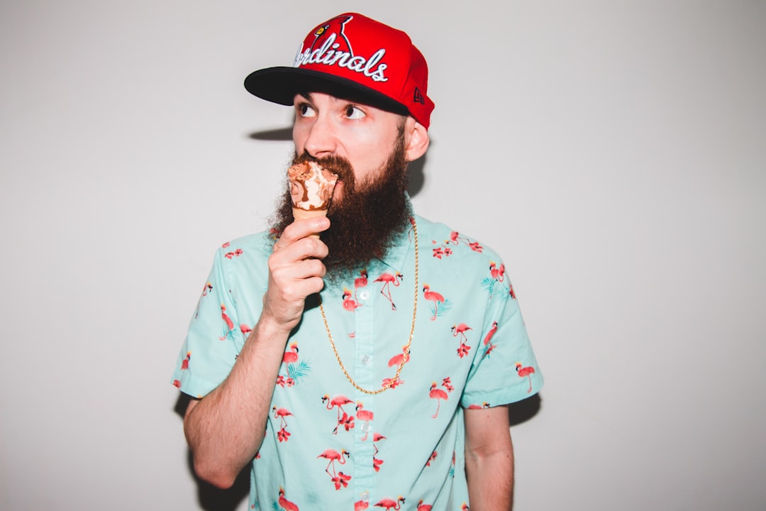 man in pink and white crew neck t-shirt eating ice cream