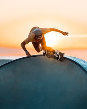 woman in white shirt and black pants jumping on black round trampoline during daytime