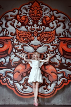 woman in white dress standing in front of red and white wall