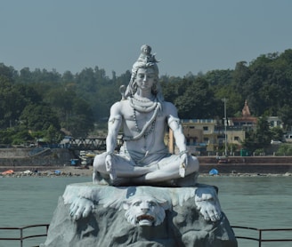 white statue of man on water fountain