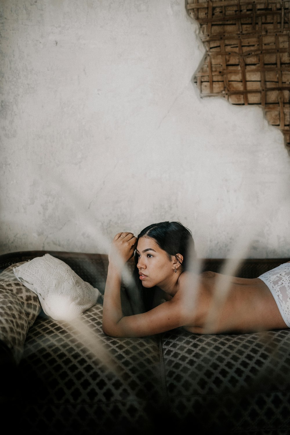 woman in white tank top lying on bed