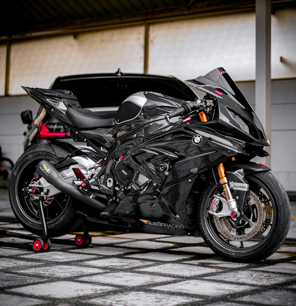 black sports bike parked on sidewalk during daytime