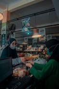 woman in green long sleeve shirt standing near woman in black hijab
