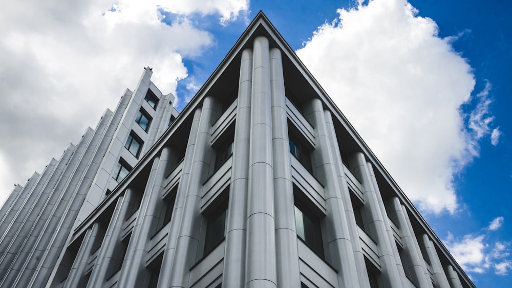 gray concrete building under blue sky and white clouds during daytime