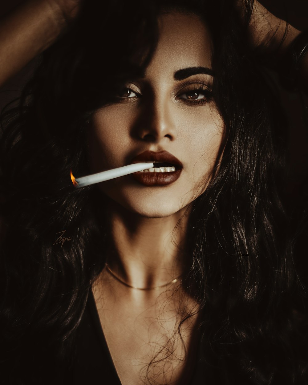 Frau mit rotem Lippenstift hält Zigarette