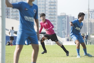 man in blue and white soccer jersey shirt and black shorts running on green grass field
