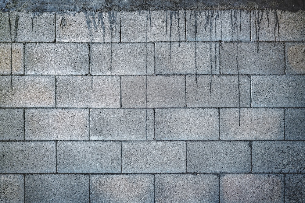 mur de briques grises pendant la journée