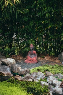 a statue of a person sitting in a garden