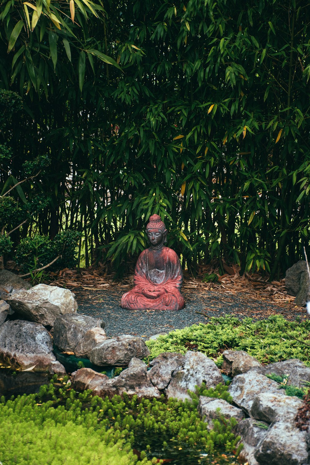 a statue of a person sitting in a garden