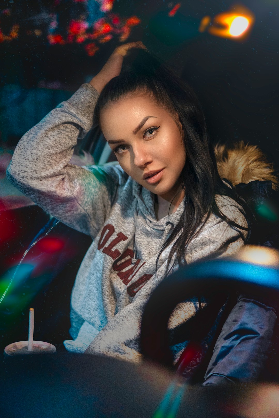 woman in gray hoodie holding steering wheel