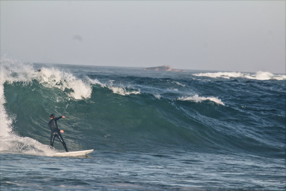 person surfing on sea waves during daytime