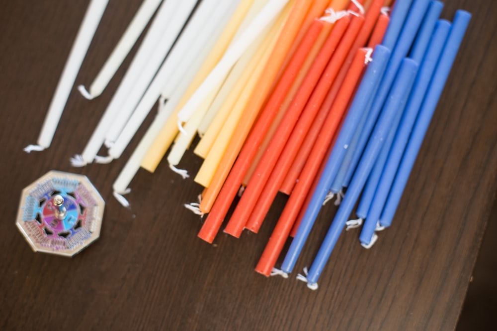 blue and orange sticks on black wooden table