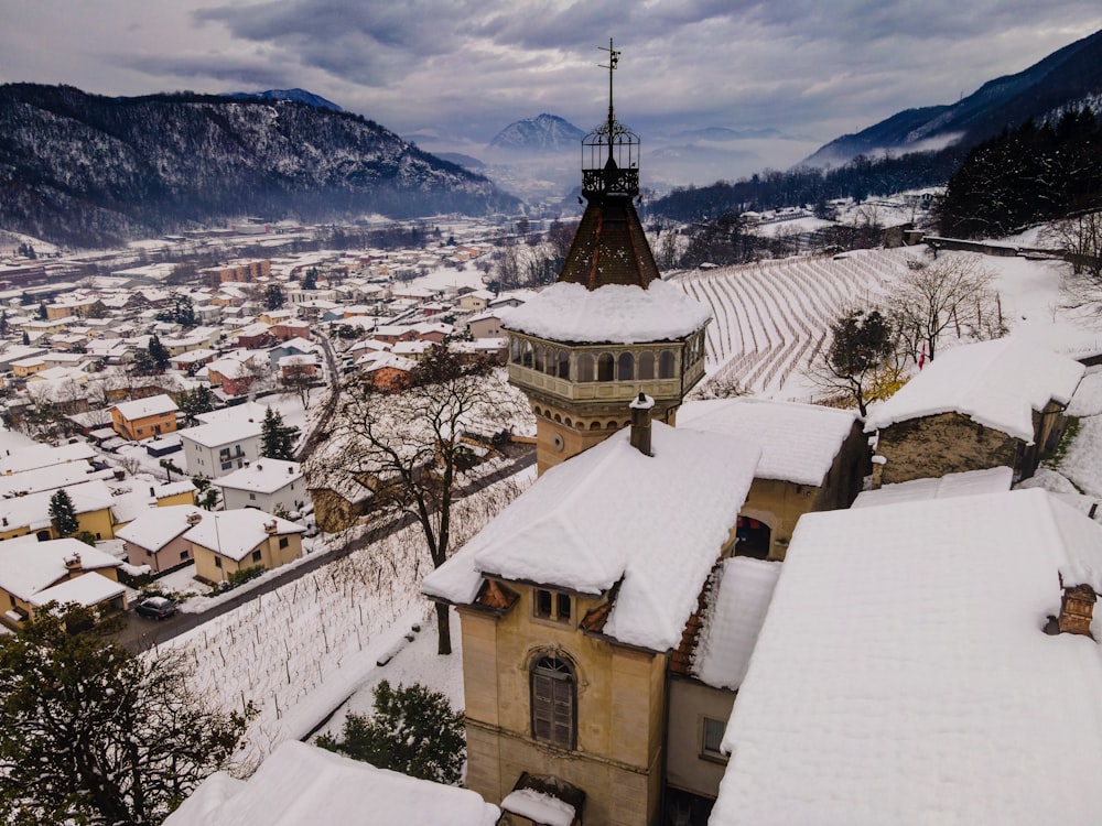 white and brown concrete building near snow covered mountain during daytime