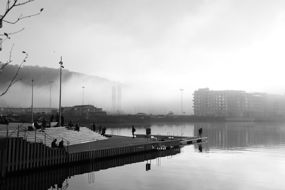 grayscale photo of a dock on a lake