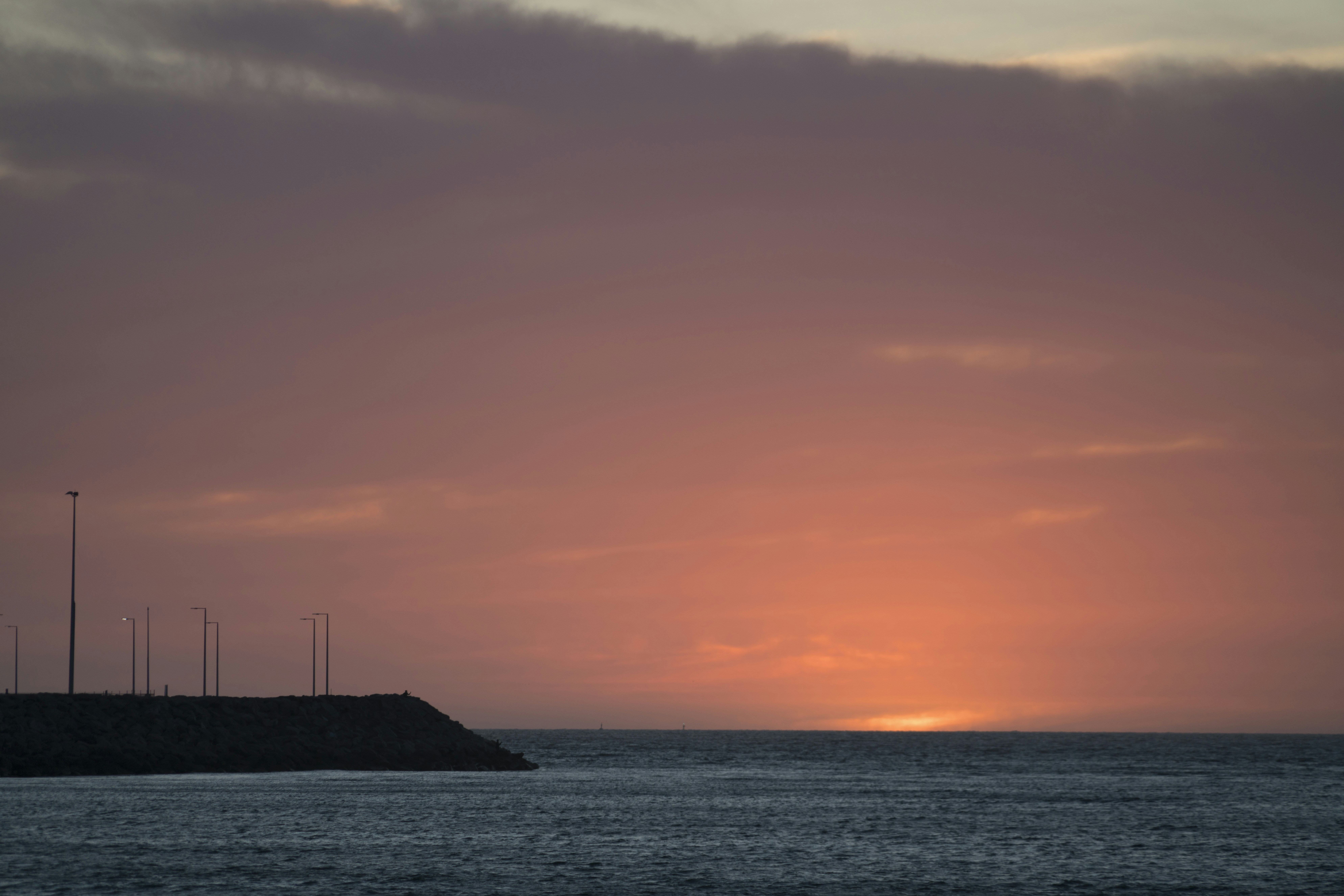 silhouette of sailboat on sea during sunset