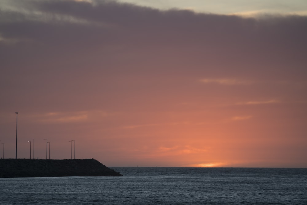 silhouette of sailboat on sea during sunset