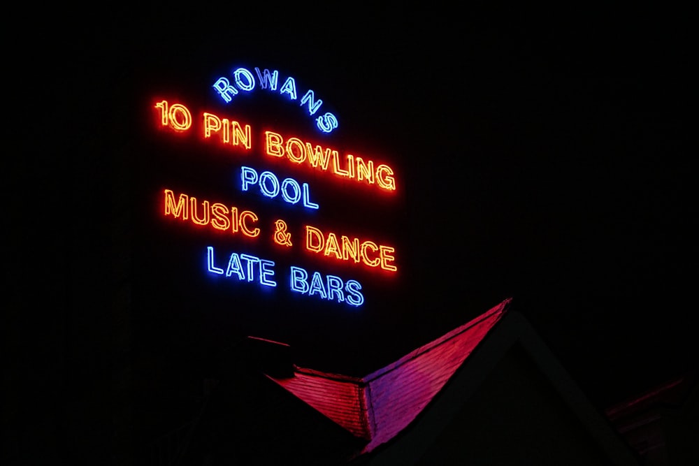 a neon sign is lit up in the dark