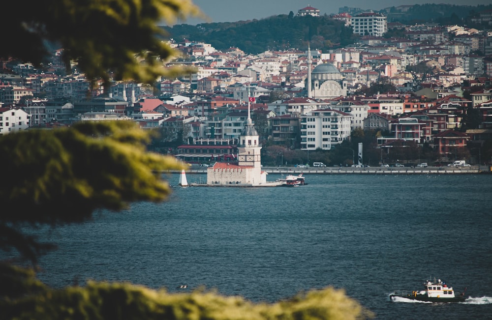 white ship on sea near city buildings during daytime