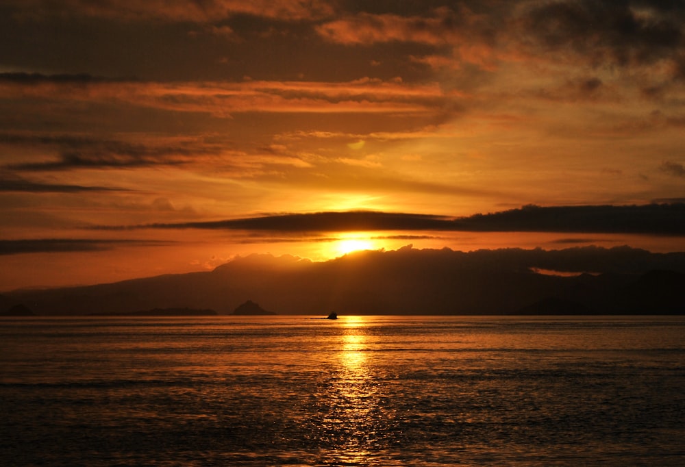 silhouette of boat on sea during sunset