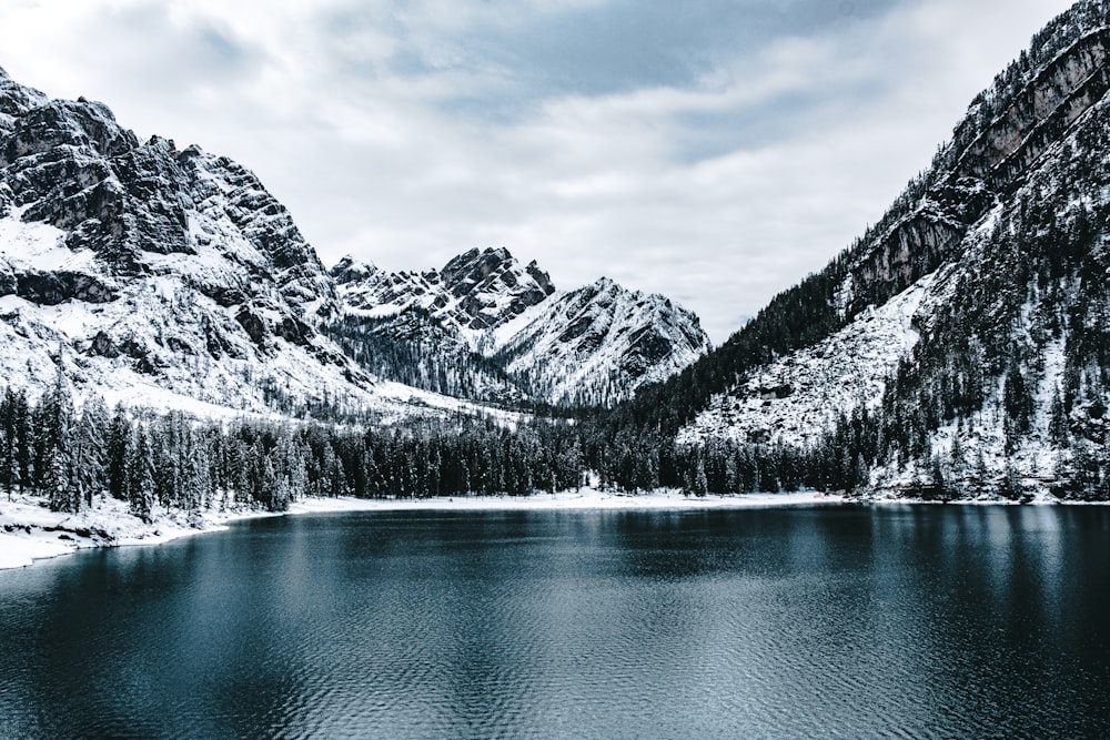 snow covered mountain near body of water during daytime