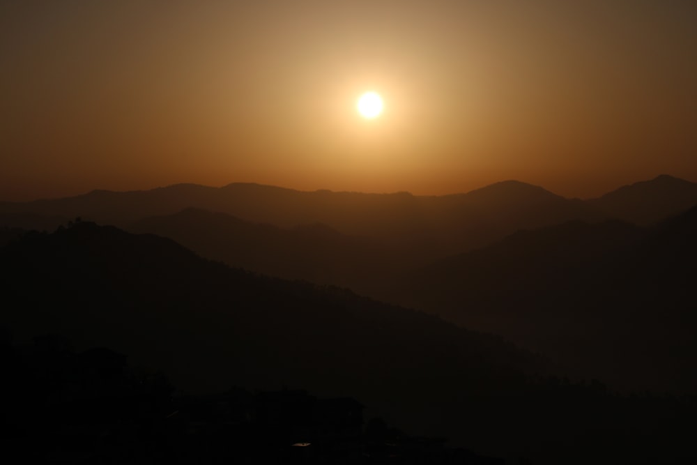 日没時の山の上の太陽