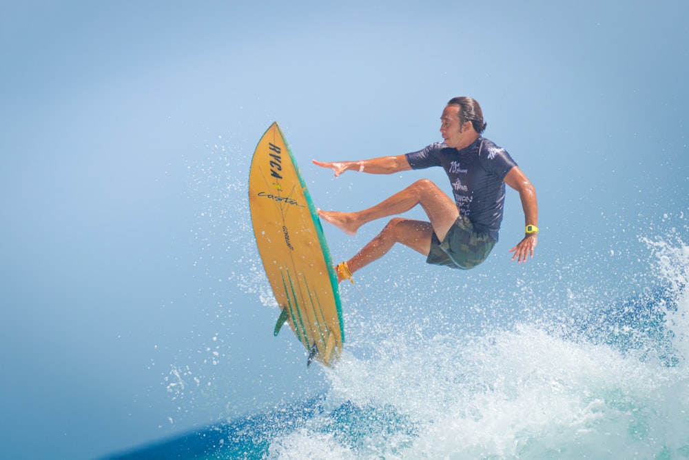 man in black wetsuit surfing on sea waves during daytime