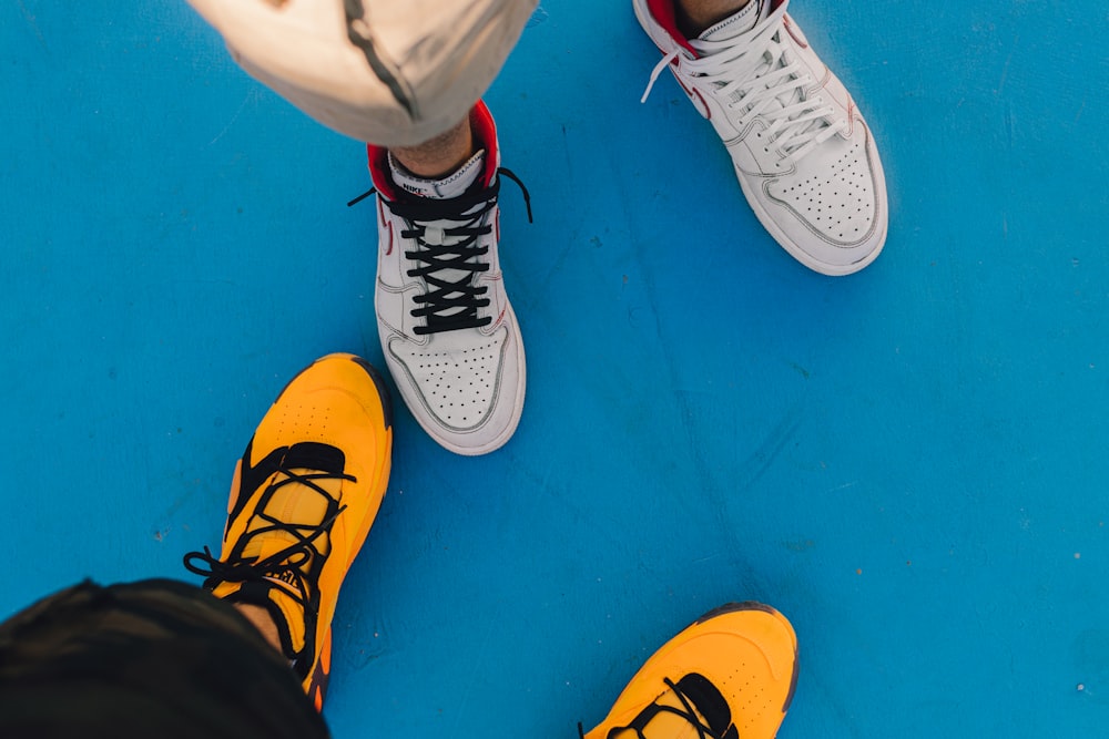person wearing white and yellow nike sneakers