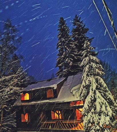 Snow-covered Poconos cabin glowing warmly from inside on a crisp winter evening.