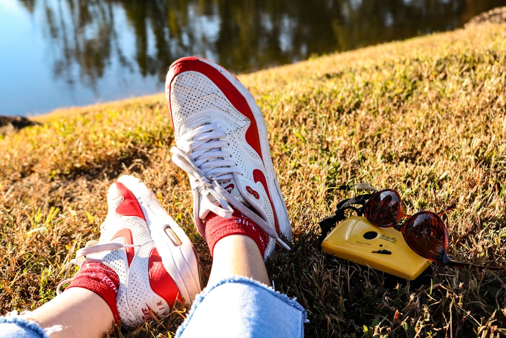 person wearing white and red nike sneakers