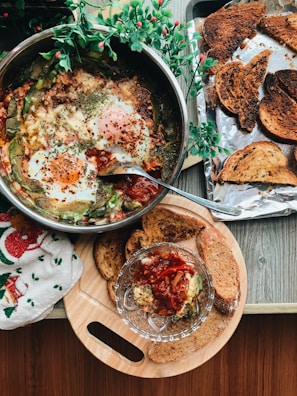 A rustic wooden table with freshly cooked eggs and herbs.