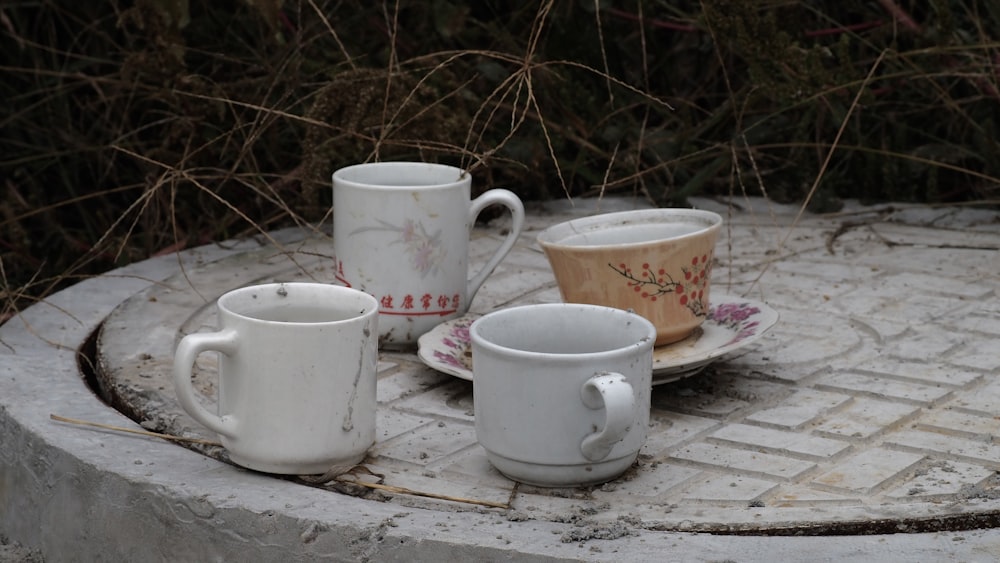 white ceramic mug on white and pink floral ceramic saucer